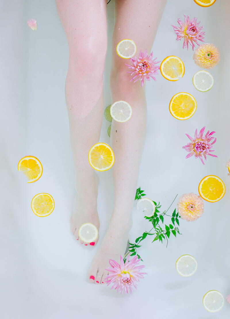 image of legs and feet with floating orange slices and flowers